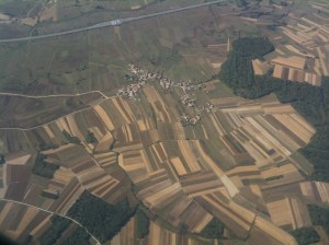 Patchwork strips of agricultural land - it is traditional for families to have some land and if they live in the countryside they will often have a day-job but also keep some chickens, a cow and maybe grow some maize or hay as well.