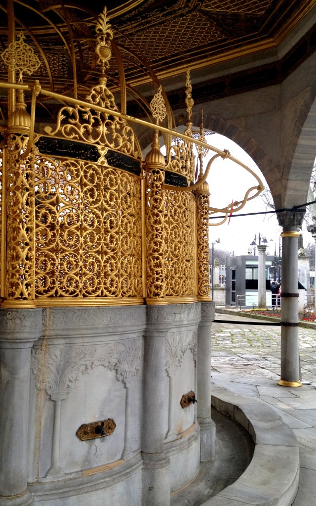 Modest taps, ornate water tank.