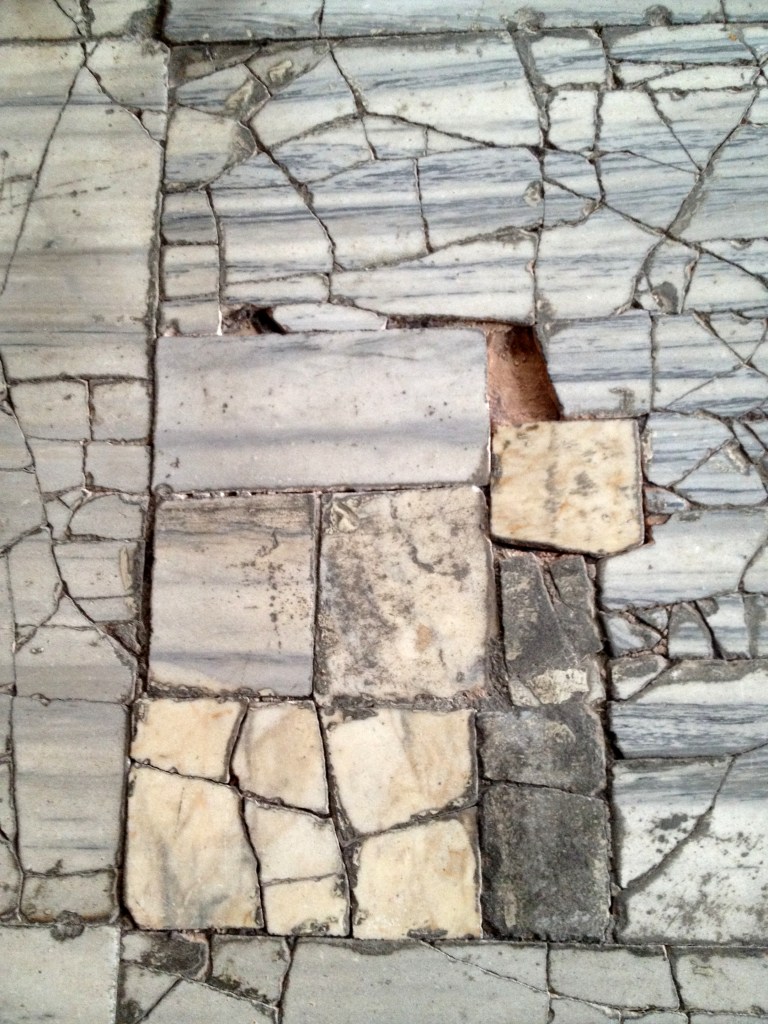 A churchwarden's nightmare - loose tiles, or - in this case - broken marble, on the floor.  They make a tinkling noise when you step on them.